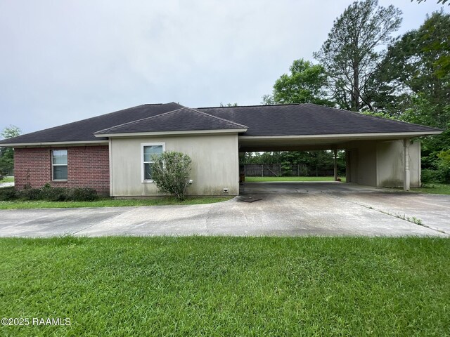 view of property exterior with a lawn, a carport, and driveway