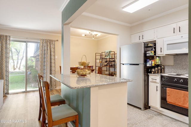 211 Versailles Blvd Unit 5, Lafayette, LA 70501 - kitchen featuring crown molding, white microwave, range with electric stovetop, and freestanding refrigerator