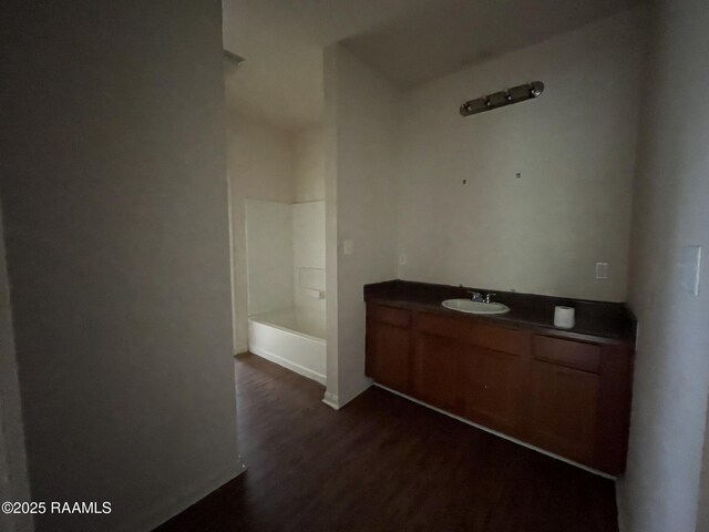 bathroom featuring a bath, walk in shower, vanity, and wood finished floors