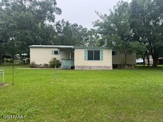 4804 Dolphin St, New Iberia, LA 70560 - rear view of house featuring a lawn