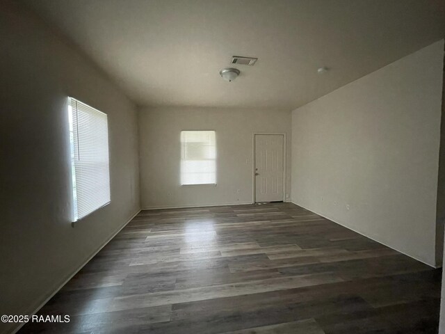 empty room with visible vents and dark wood-style flooring