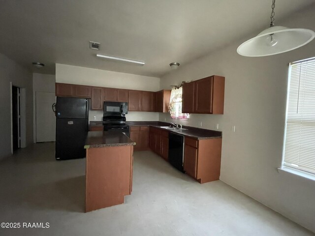 kitchen with dark countertops, visible vents, a sink, a center island, and black appliances