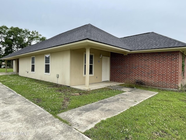 view of front of property featuring a front lawn, brick siding, and a shingled roof