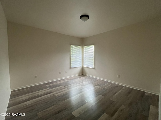 spare room featuring wood finished floors and baseboards