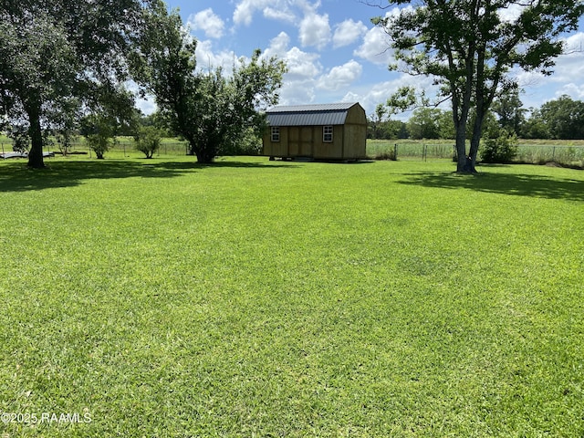 view of yard with a shed, an outbuilding, and fence