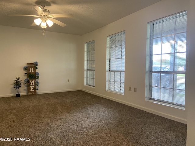 unfurnished room featuring baseboards, a textured ceiling, ceiling fan, and dark carpet