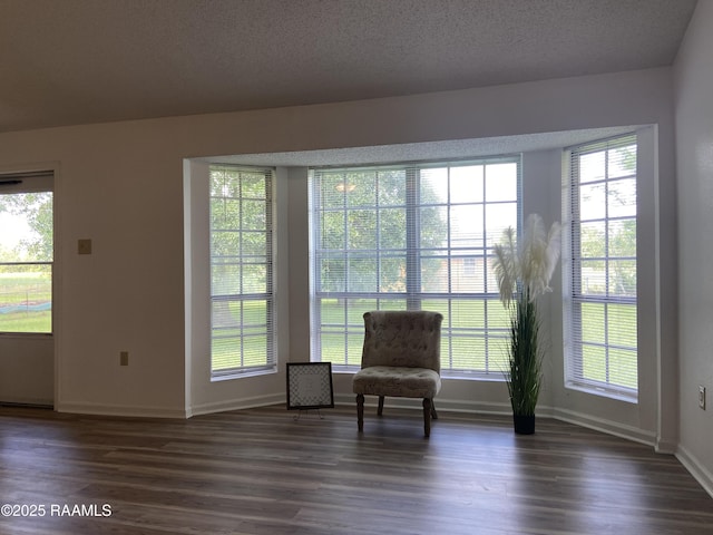 living area featuring baseboards and dark wood-style flooring
