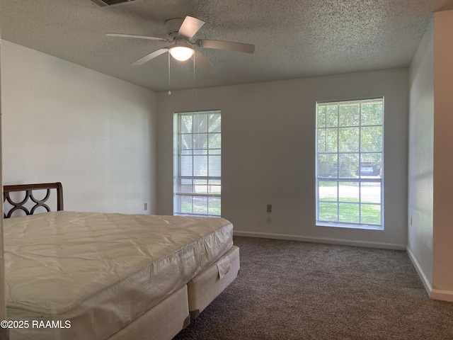 carpeted bedroom featuring baseboards, a textured ceiling, ceiling fan, and visible vents