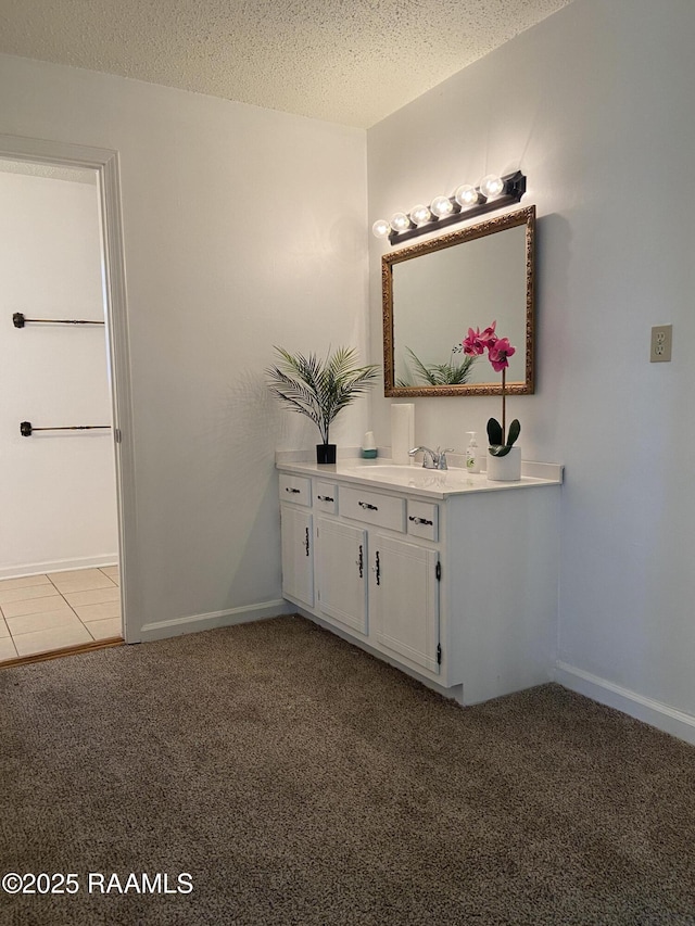 bathroom featuring vanity, a textured ceiling, and baseboards