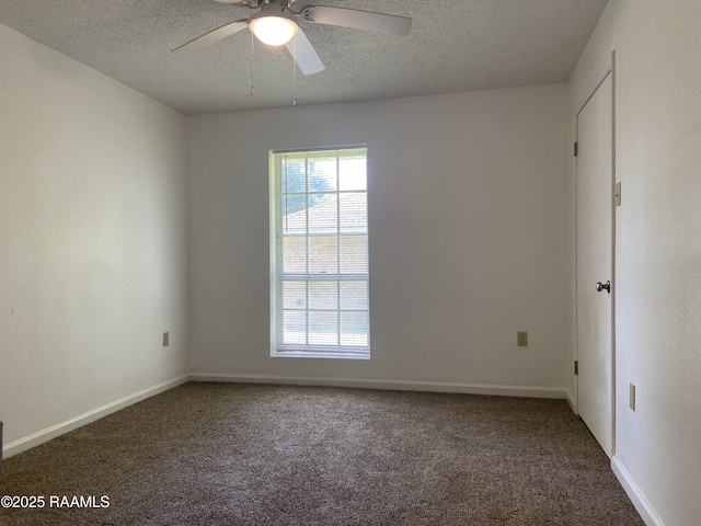 carpeted spare room featuring baseboards, a ceiling fan, and a textured ceiling