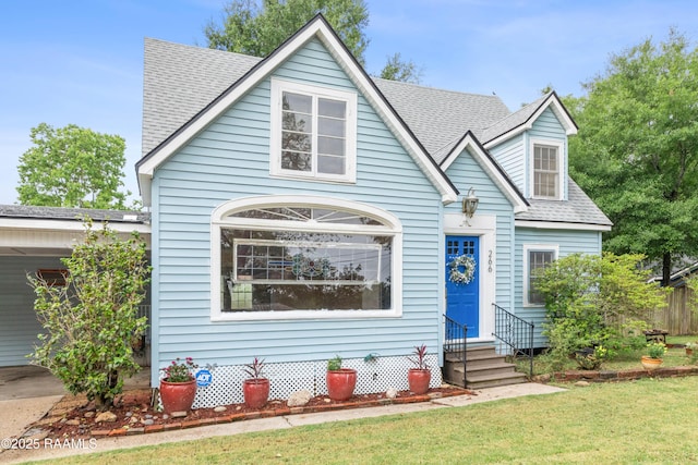 view of front of home featuring roof with shingles, a front yard, and entry steps