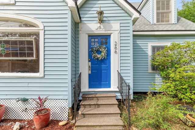 property entrance with a shingled roof