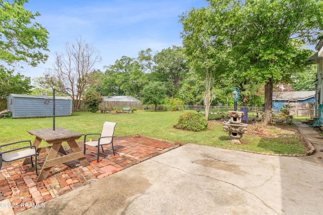 view of patio / terrace featuring an outdoor structure, outdoor dining space, and a fenced backyard