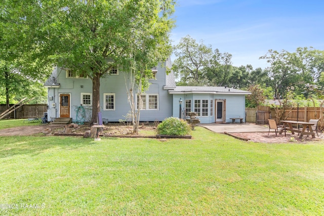 rear view of house featuring fence, a lawn, entry steps, and a patio