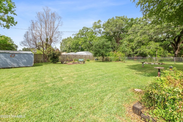 view of yard featuring a fenced backyard, a shed, and an outdoor structure