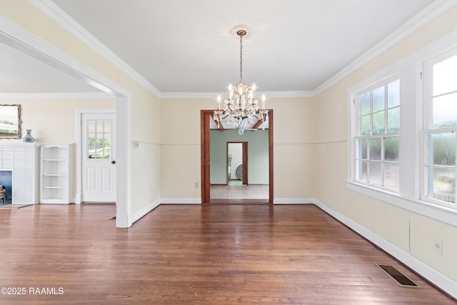 unfurnished dining area with visible vents, wood finished floors, a notable chandelier, and ornamental molding