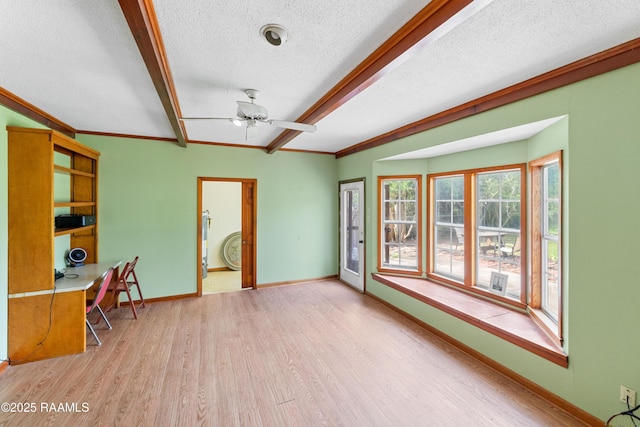 interior space with a textured ceiling, ceiling fan, beam ceiling, ornamental molding, and wood finished floors