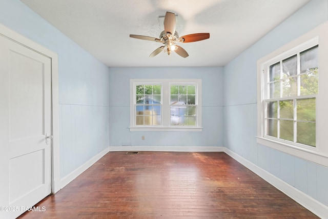 unfurnished room with visible vents, hardwood / wood-style flooring, a ceiling fan, and baseboards