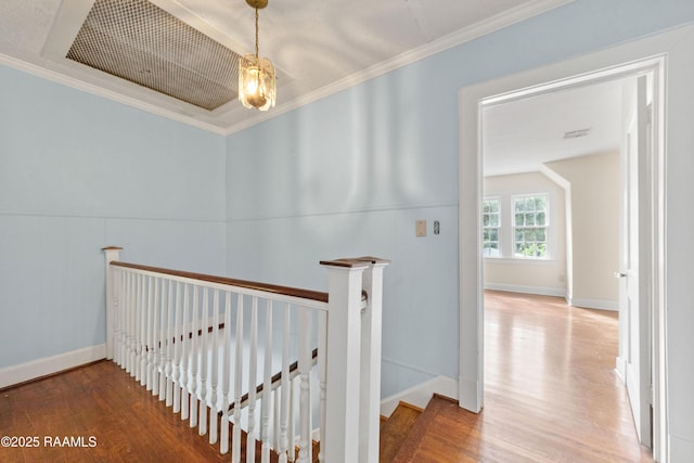 hall featuring an upstairs landing, wood finished floors, and crown molding