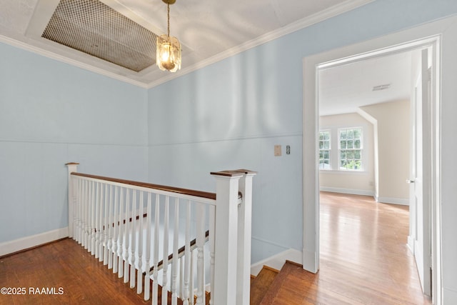 corridor featuring visible vents, wood finished floors, an upstairs landing, and ornamental molding
