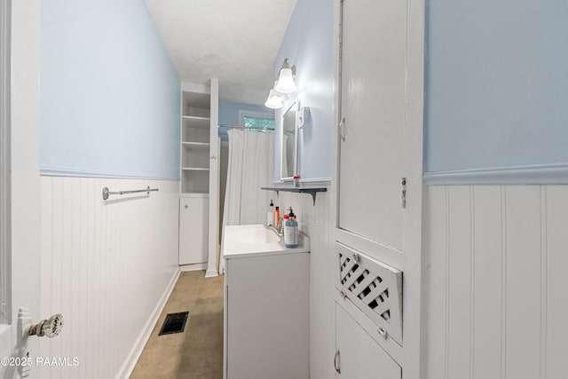 full bath featuring visible vents, wainscoting, and vanity