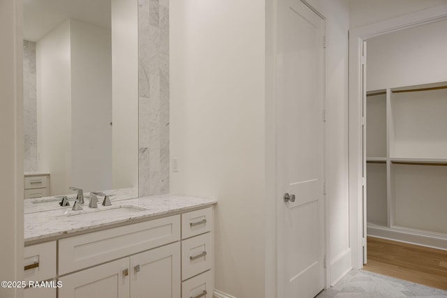 102 Drifting Sands Ln, Lafayette, LA 70503 - bathroom with baseboards, wood finished floors, a walk in closet, and vanity