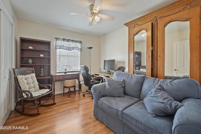 living area with ceiling fan and light wood-style flooring