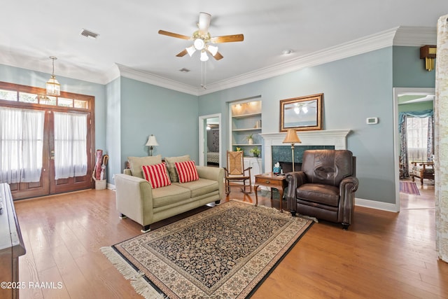 living area with visible vents, built in features, french doors, and plenty of natural light