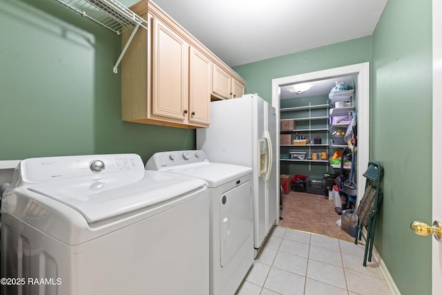 laundry area featuring light tile patterned floors, cabinet space, light colored carpet, and washing machine and dryer