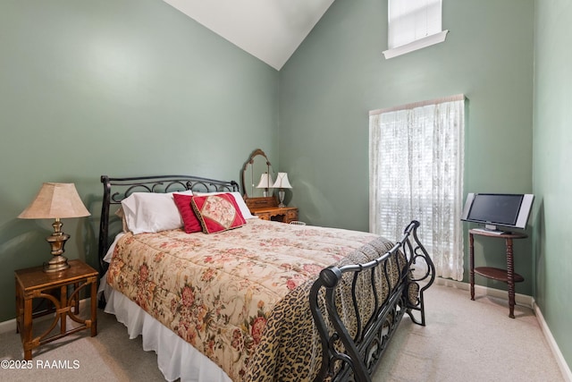 carpeted bedroom with baseboards and high vaulted ceiling