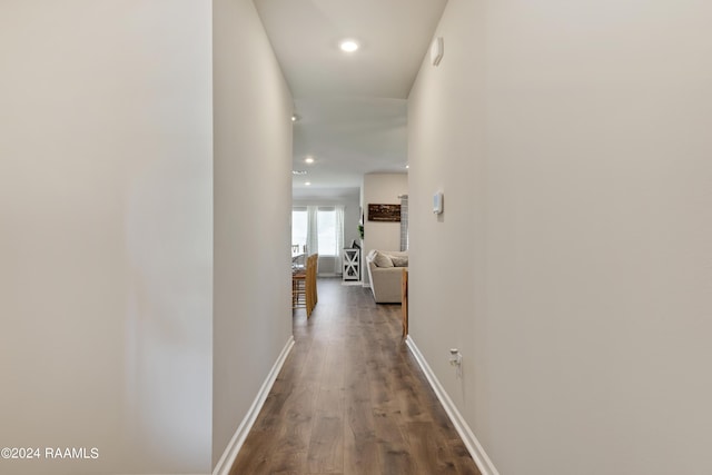 corridor with wood finished floors, recessed lighting, and baseboards