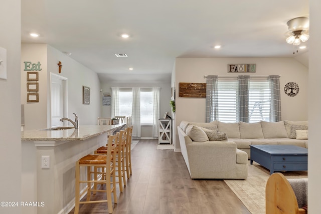 living room with visible vents, recessed lighting, and light wood finished floors