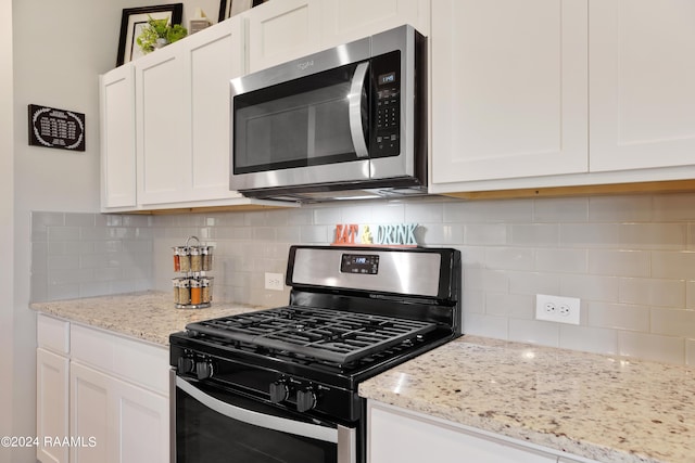 kitchen with white cabinetry, stainless steel appliances, and backsplash