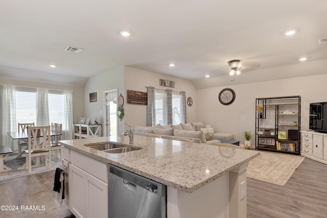 kitchen with stainless steel dishwasher, light wood-style flooring, a sink, visible vents, and a center island with sink