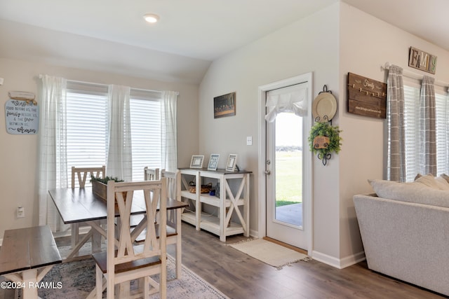 dining space with lofted ceiling, wood finished floors, and baseboards