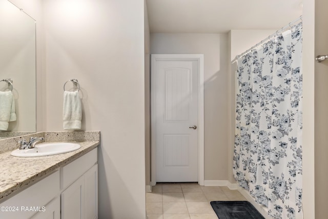 bathroom with tile patterned floors, baseboards, a shower with shower curtain, and vanity