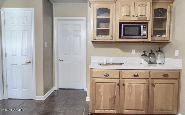 707 W Pine St, Erath, LA 70533 - kitchen featuring stainless steel microwave, glass insert cabinets, dark tile patterned flooring, and light countertops