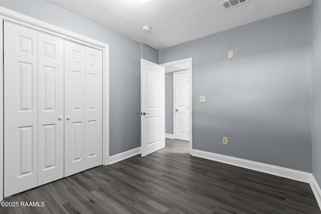 unfurnished bedroom featuring visible vents, baseboards, and dark wood-style floors