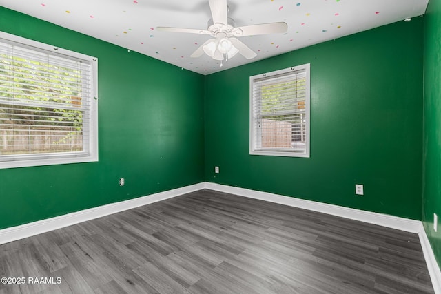 empty room with baseboards, ceiling fan, and wood finished floors