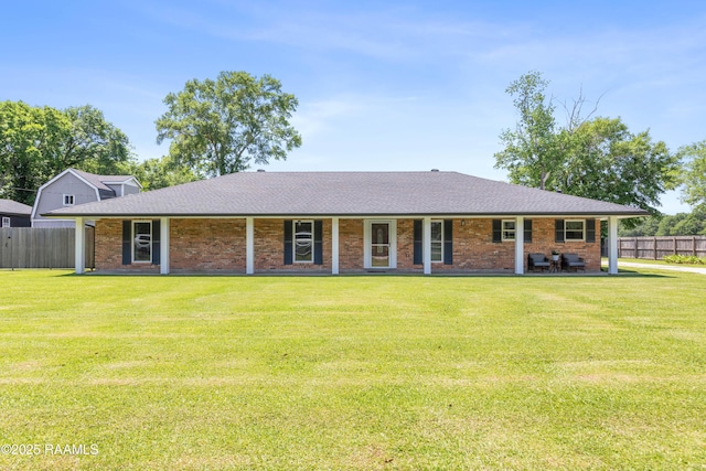 view of front facade featuring a front lawn, roof with shingles, and fence