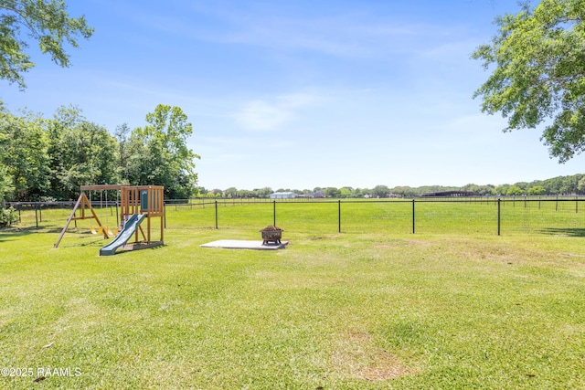 view of yard featuring fence, a rural view, and a playground