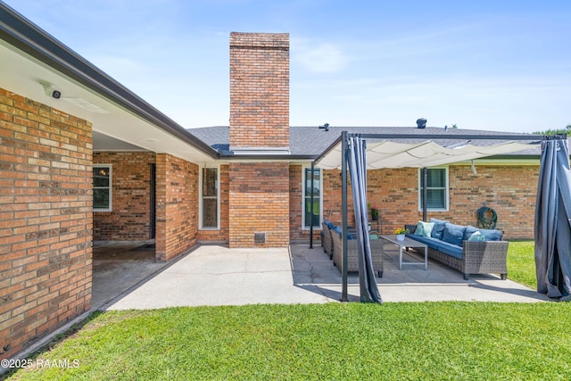 rear view of property featuring a chimney, an outdoor living space, brick siding, and a patio