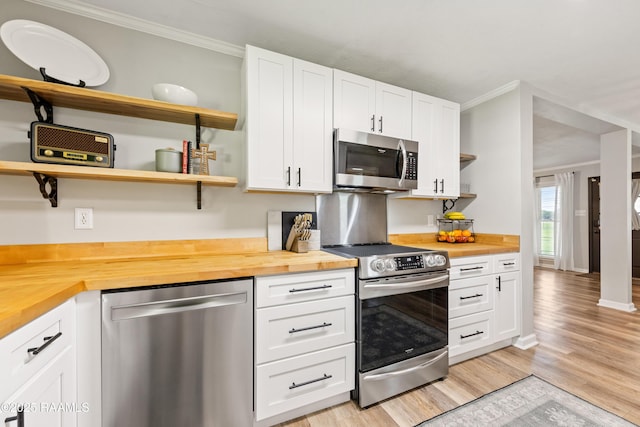 kitchen with stainless steel appliances, open shelves, and butcher block counters