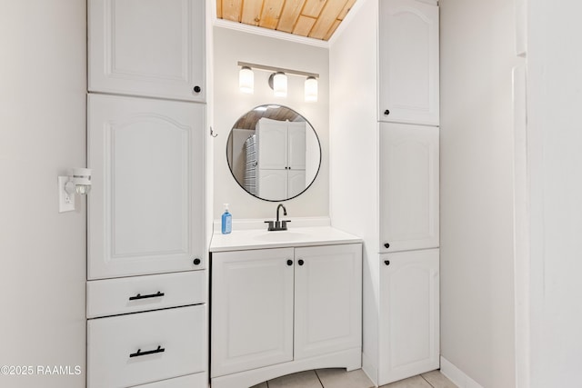 bathroom with crown molding, tile patterned flooring, vanity, and baseboards