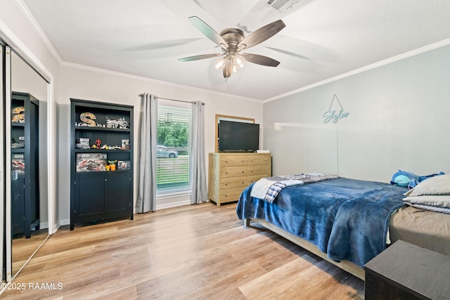 bedroom with ornamental molding, light wood finished floors, a ceiling fan, and visible vents