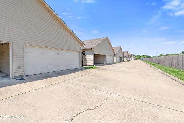 4000 Mchugh Rd Unit 102, Zachary, LA 70791 - view of side of home featuring fence, concrete driveway, and a garage