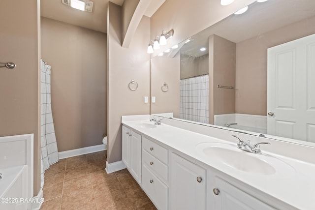 4000 Mchugh Rd Unit 102, Zachary, LA 70791 - bathroom featuring toilet, double vanity, baseboards, tile patterned floors, and a bath