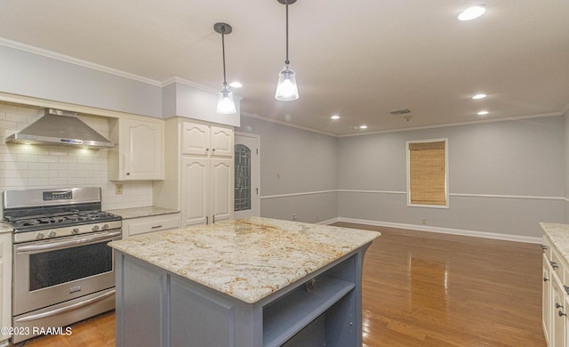 110 Karen Dr, Lafayette, LA 70503 - kitchen featuring gas range, wall chimney range hood, a kitchen island, ornamental molding, and backsplash