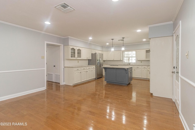 110 Karen Dr, Lafayette, LA 70503 - kitchen featuring crown molding, stainless steel fridge, visible vents, and white cabinetry