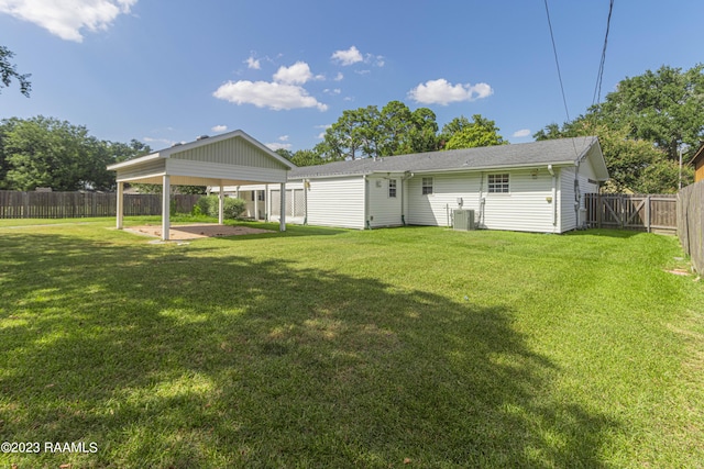 110 Karen Dr, Lafayette, LA 70503 - rear view of house with a fenced backyard, a yard, central air condition unit, a patio, and a carport